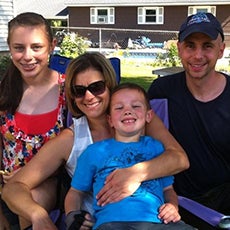 Chris Richards smiling with his wide and two children