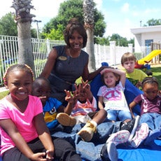 Teacher surrounded by young children