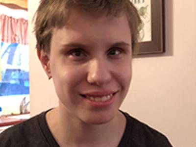 Alicia Krage headshot. Alicia a white woman smile at the camera. She has short brunette hair. 