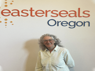 An older woman standing in front of the Easterseals Oregon sign