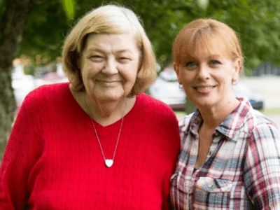 Easterseals program participant, Eleanor, stands smiling in a park with an Easterseals Direct Support Professional