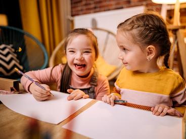 Shot of two sisters completing their homework togethe