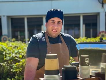 Leandro standing by his coffee cart