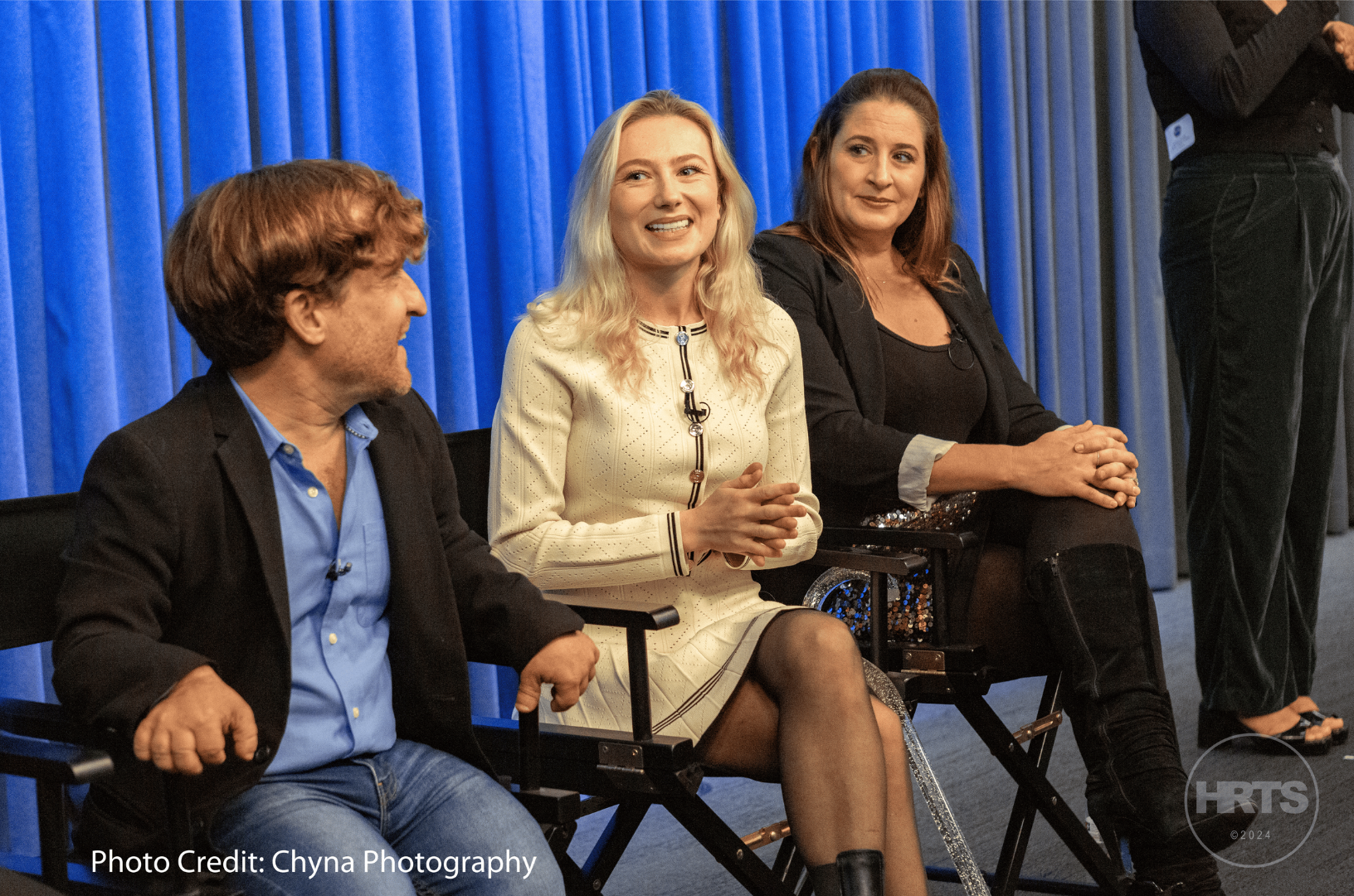 Three people in a panel setting engaging in a conversation. 